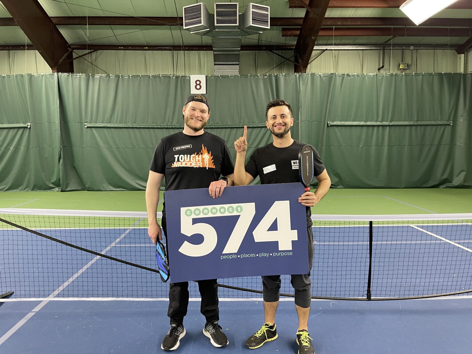 the winners of our Pickleball Tournament celebrate by posing with the Connect 574 sign